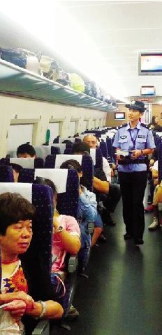 女乘警李娜巡視車廂加強(qiáng)列車治安防范。