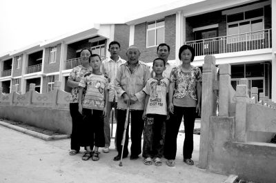③2011年6月27日下午，何兆胜(中)抵达新居后和家人的合影。 淅川县委宣传部供图