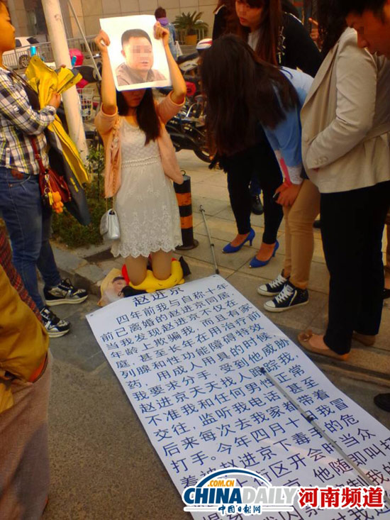女孩雙膝跪地 地上放著舉報(bào)材料