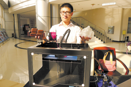80后硕士赵科研向记者展示他和团队自主研发的3D打印机和打印模型。王昱 摄