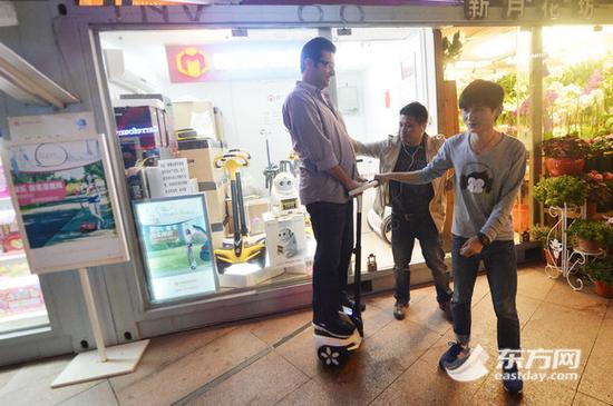 图为一位外籍顾客正在体验电动平衡车