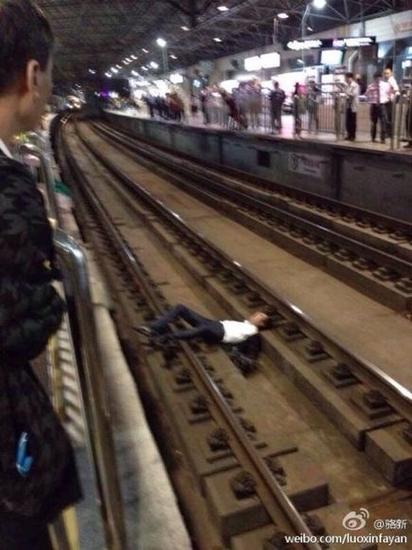 网友照片显示,一名男子躺在轨道上。