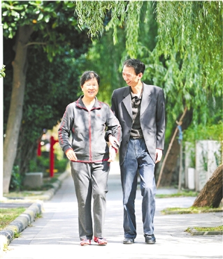 殷立明陪妻子在小区散步、锻炼身体。