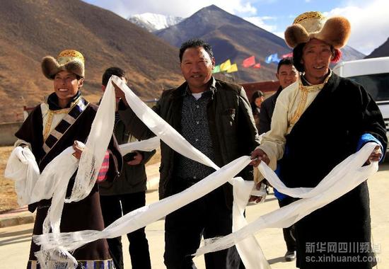 西藏墨竹工卡县的藏族村民手捧哈达欢迎游客(10月23日摄)。