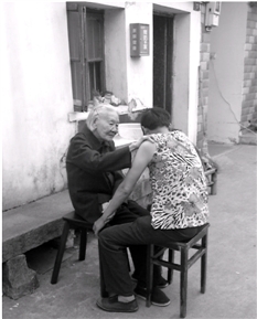 程奶奶在为邱小芬按摩胳膊。记者李竹青摄
