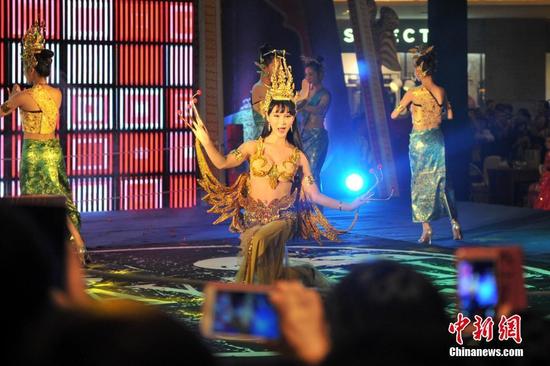 一浑身挂满黄金首饰的美女坐在福州商场内,吸引许多民众驻足观看。