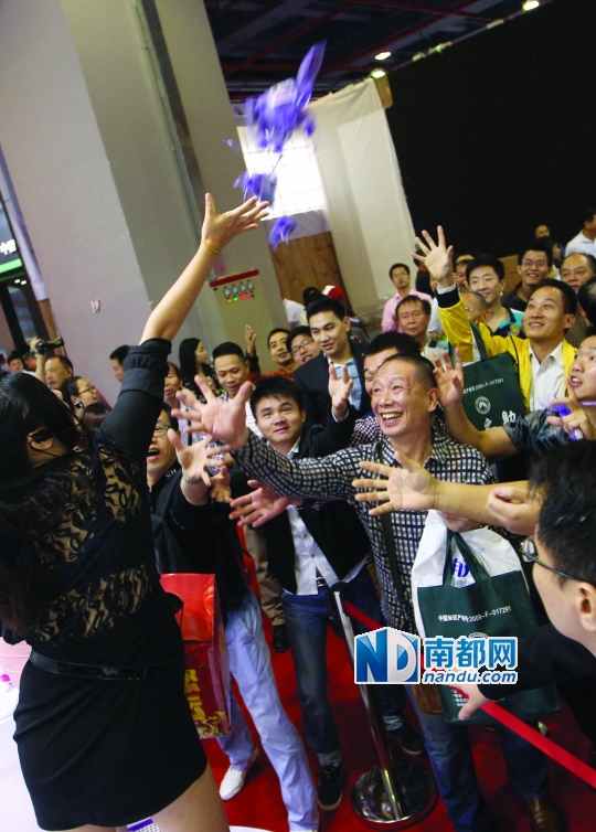 昨日,广州性文化节上,一个情趣用品展台抛发小礼品,引来观众争抢。南都记者 马强 实习生 张梓望 摄