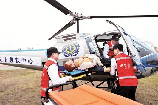 图为：“2014年武汉市紧急医疗救援演练”昨日举行，一架直升机赶来抢救“伤员”。但在现实中，空中急救在武汉早已停飞。 记者魏铼摄