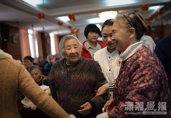 福利中心的工作人员和义工为老人举办生日宴会。