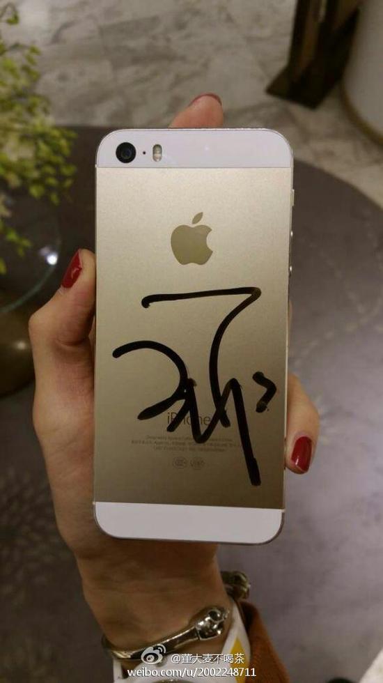 王菲在手机背面为粉丝签名