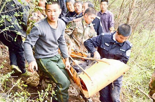 图为：老人的遗体被抬出深山