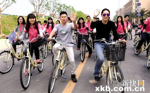 ■奥运冠军李小鹏(左)和罗雪娟(右)与学生们一起骑行暨大南校区。新快报记者 夏世焱/摄