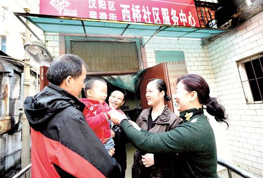 圖為:張偉抱著兒子感謝社區(qū)群干