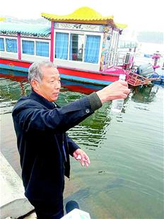 图为：赵久富舀上一瓶汉江水去北京。