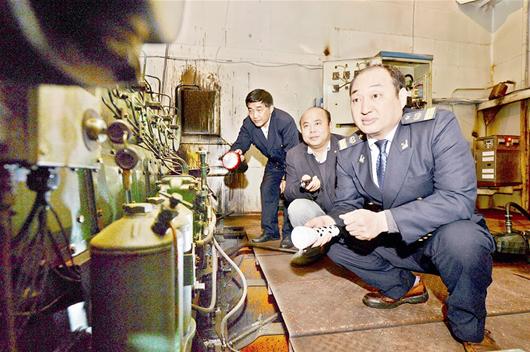 圖為：肖剛和同事登上貨船，進(jìn)入輪機(jī)艙檢查設(shè)備安全。
