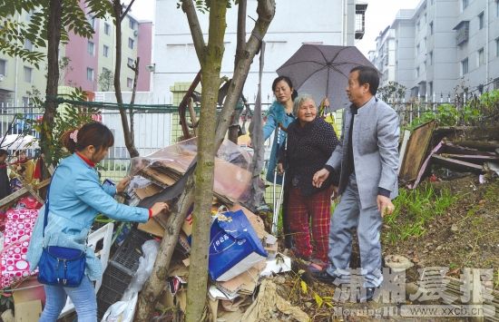 11月16日，冷水江市的一廉租房小区内，爱心志愿者与刘慈娥老人一起将捡来的废品堆积好。图/潇湘晨报通讯员张计平