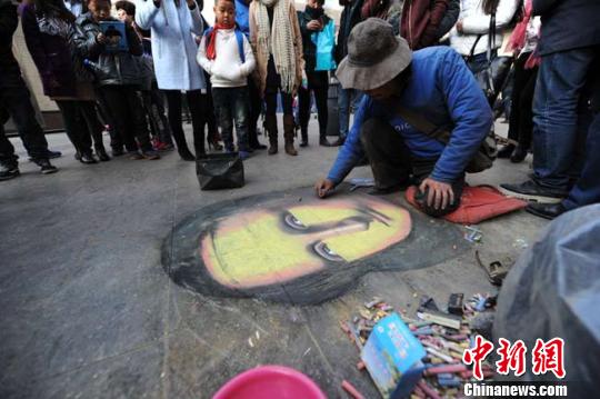 11月22日，“蒙娜麗莎的神秘微笑”出現(xiàn)在蘭州繁華城區(qū)的人行道地磚之上，這幅用粉筆涂抹而成的“蒙娜麗莎”看上去栩栩如生，猶如西方油畫一般細膩柔滑的質(zhì)感引得當?shù)孛癖妼ρ矍暗摹笆澜缑嫛斌@嘆不已?！钇G敏攝
