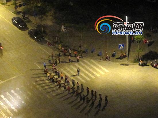 从赵先生家楼下看去，数十名大妈正在公路的斑马线上跳舞。