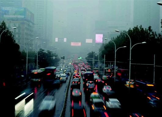 圖為：霾夾雨，晝?nèi)缫埂Ｗ蛉障挛?點(diǎn)多鐘，武昌中南路一片灰暗，許多車輛開啟燈光行駛