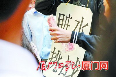 青年身挂“脏水挑战”的纸牌。