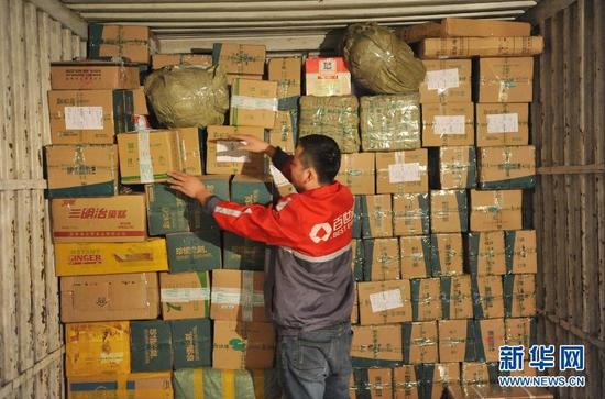 11月24日，浙江省临安市一家快递公司的工作人员将包裹装车。