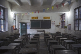 11月26日，涟源桥头河镇大屋联校，教室里灯光昏暗，讲台课桌非常简陋。