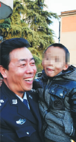 林州市公安局长赵峰抱着满脸笑容的晓宇(化名)，也露出了笑容