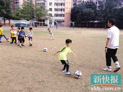 ■在广铁一中光秃秃的足球场，一群小学生在练习传球。黄婷/摄