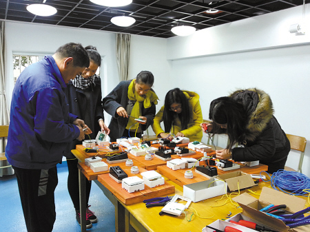 学生们正在跟电工师傅学习。