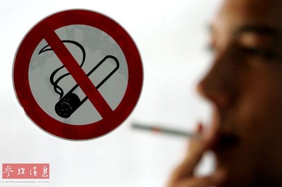 资料图片:一名男子在禁烟标志后吸烟。