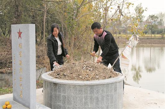 程加富和妻子在打扫烈士墓