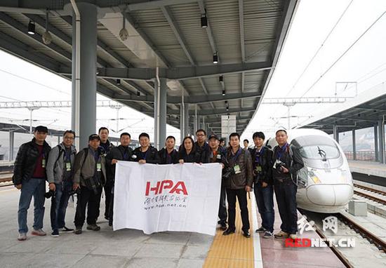 在本次高铁试运行的终点站怀化南站，舒勇与参加试运行体验的10位摄影师合影留念。
