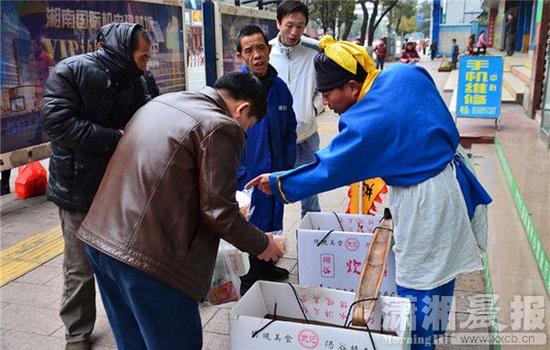 郴州市街头，一位古装打扮的男子挑着“武大郎”炊饼的担子沿街大声吆喝叫卖。图/潇湘晨报通讯员 贺茂峰