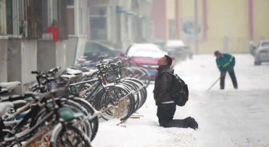 小伙子跪在楼前，一直抬头看着楼上 本报记者 孙立国 摄