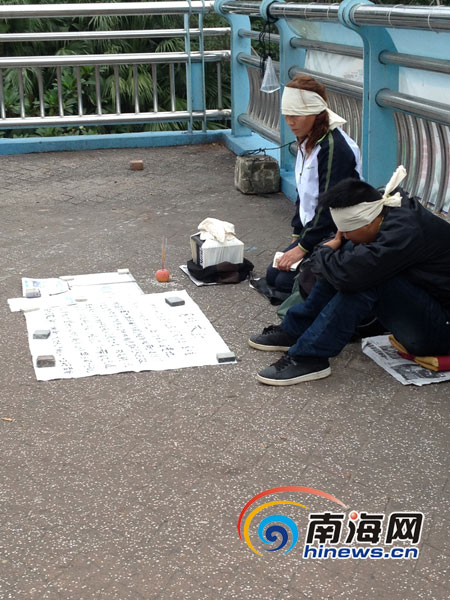 一男一女街头披麻戴孝在海口明珠广场天桥乞讨路费。南国都市报记者王洪旭摄