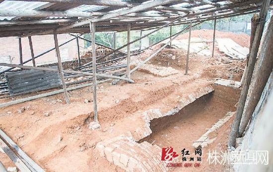 东汉古墓已被围挡围住，墓地上方也搭建了雨棚(记者 汪成 摄)