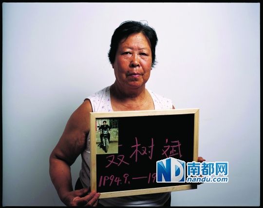 去年9月，河北省高院宣布王书金案与聂树斌案无关后，聂树斌母亲举着儿子的照片表示不服。南都记者 郭现中 摄