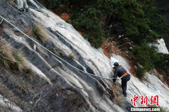 清洁工在陡峭的山崖上步履维艰