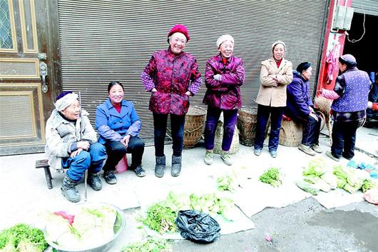 图为:黄土工作站赶集时,街边卖菜老农,年龄多在80岁以上。