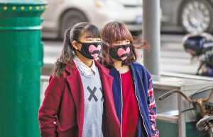 昨天,在江厦公园旁,两位女孩戴着爱心口罩出行。记者 唐严 摄