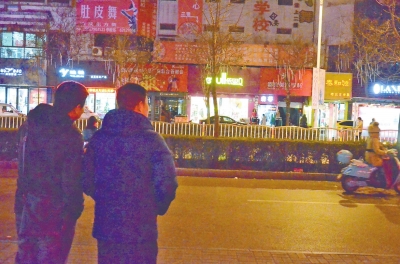 穆军炜和闫龙峰一起，隔着街道查看对面商铺内的可疑人员。