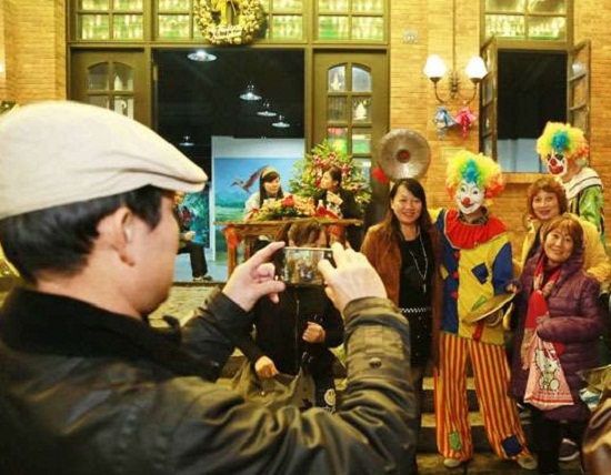 现场工作人员假扮小丑与游客合影