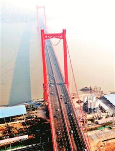 图为：红色的鹦鹉洲大桥巍峨矗立在长江上