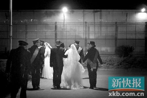 ■在狱警陪伴下,新人们依偎着走向婚礼现场。