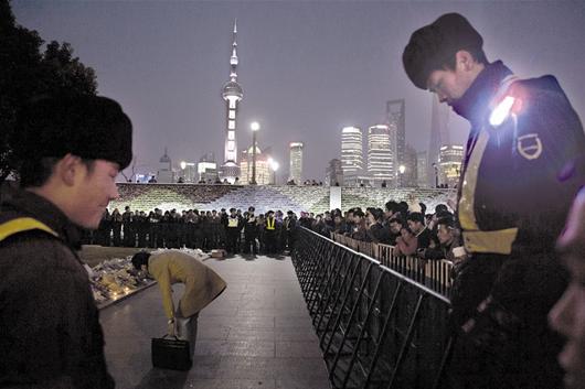 图为:昨日傍晚,上海许多市民和游客来到外滩,在陈毅广场自发献上鲜花来悼念拥挤踩踏事故不幸遇难者