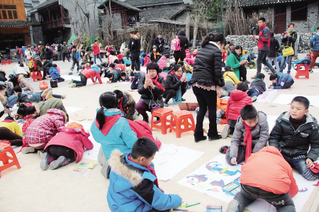 昨日，在湘西坪朗村，参加亲子跨年活动的孩子们拿起画笔画出心中的梦想。千灵坡 摄