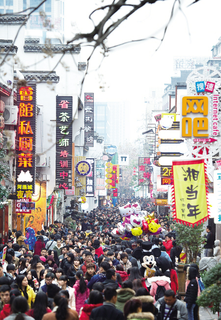 昨日是元旦小长假第二天，天气晴好，市民纷纷走出家门逛街购物。图为太平街上人头攒动。 邹麟 摄
