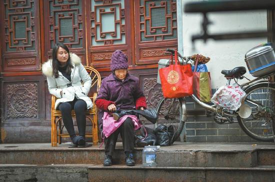 这位满脸皱纹,一手黢黑,正给人擦鞋的婆婆其实是远近闻名的“股神”。