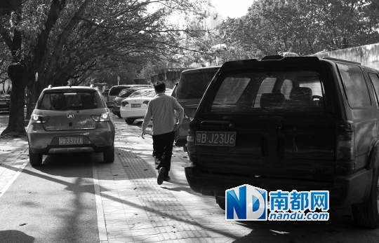 昨日下午,商报路,人行道上停满了车,行人在夹缝中行走。