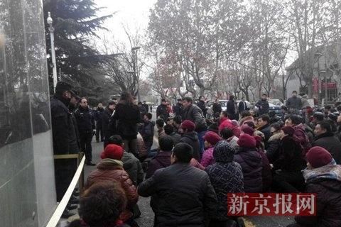 图集显示，大批人群聚集在市政府前下跪，年纪多为中老年。（图据新京报）